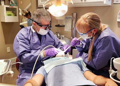 Dentist and dental assistant performing dental services