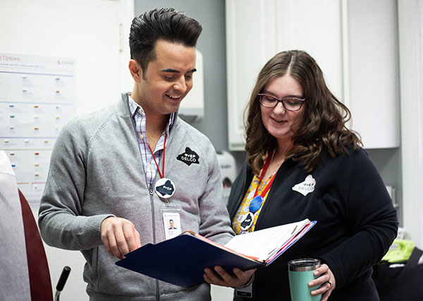 Two people looking at a binder