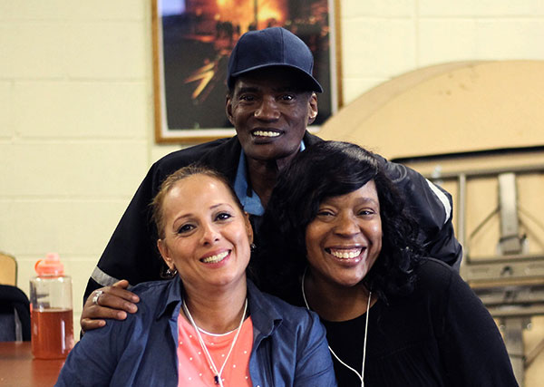 Three people hugging and smiling